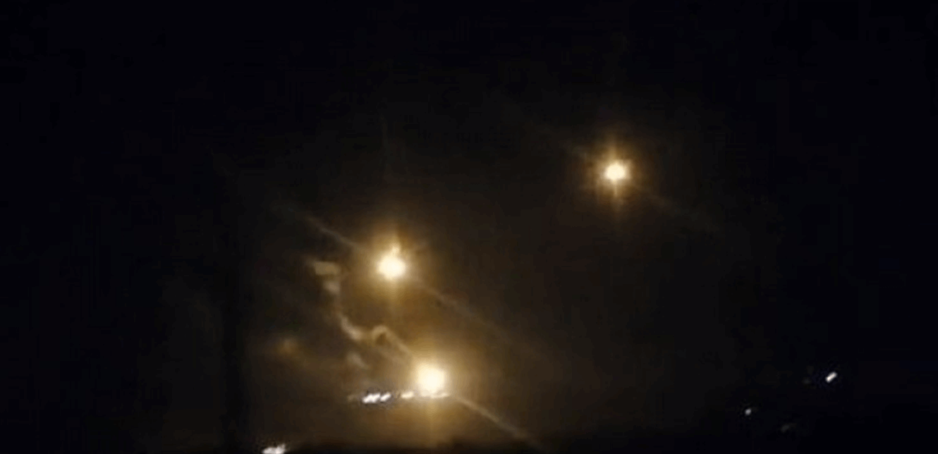 قذيفتان مضيئتان فوق علما الشعب أثناء انتشال الشهداء